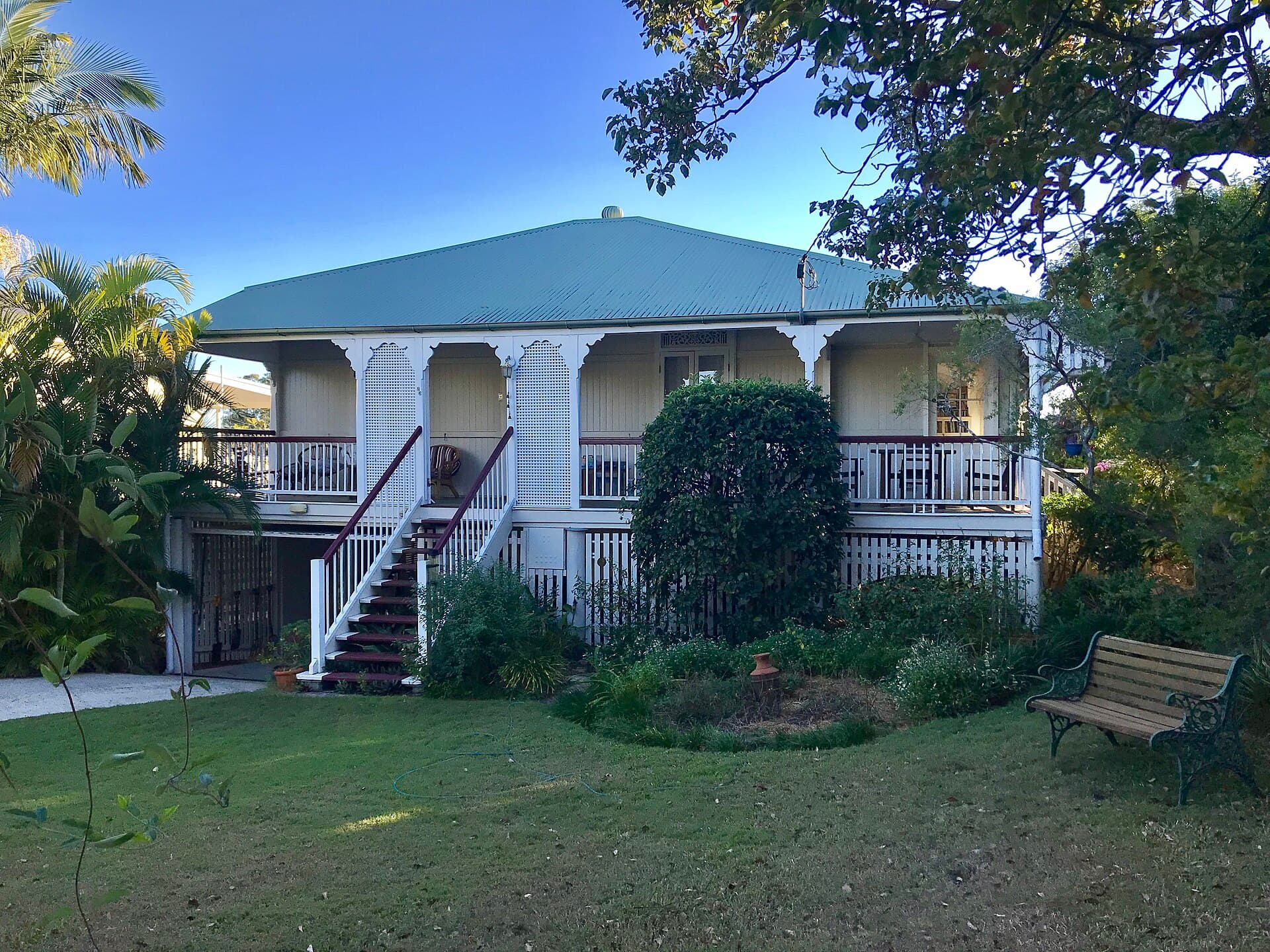 A high-set Queenslander in Corinda, where the roof, verandah, fascia and front path read as a single weathered envelope rather than as separate jobs.